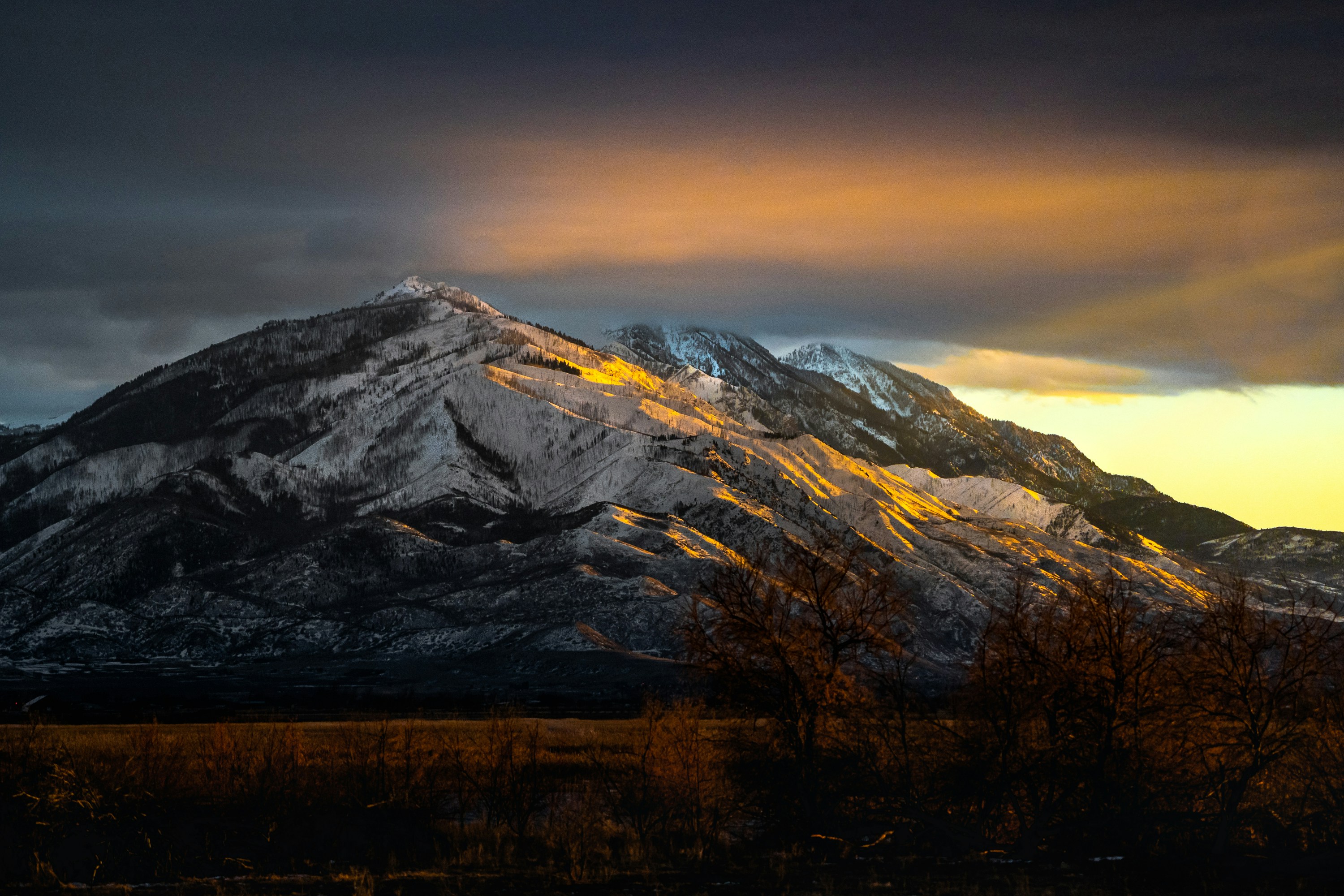 Warm evening light reaching the snow-covered ridges of Utah’s Wasatch Mountains